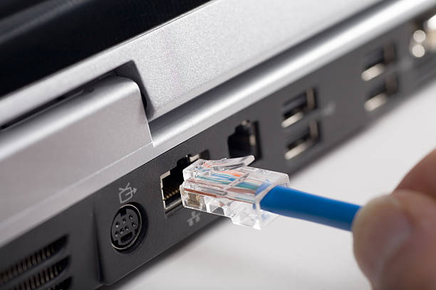 Ethernet cable being plugged into wifi range extender for improved connectivity